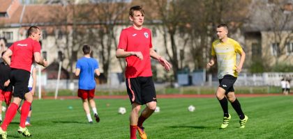 Young men practicing soccer on a sunny day at an outdoor field, focusing on exercise and teamwork.